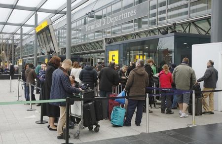 © Reuters. Passengers queue outside Terminal 3 at Heathrow Airport in west London