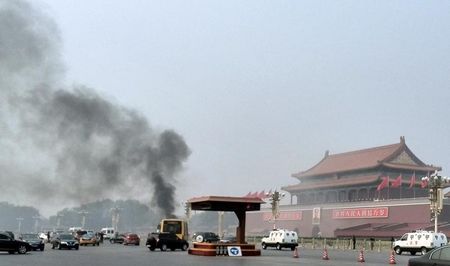 © Reuters. Vehicles travel along Chang'an Avenue as smoke raises in front of a portrait of late Chinese Chairman Mao Zedong at Tiananmen Square in Beijing