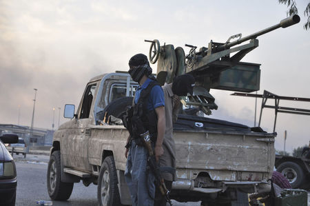 © Reuters. Fighters of the Islamic State of Iraq and the Levant (ISIL) stand guard at a checkpoint in the northern Iraq city of Mosul