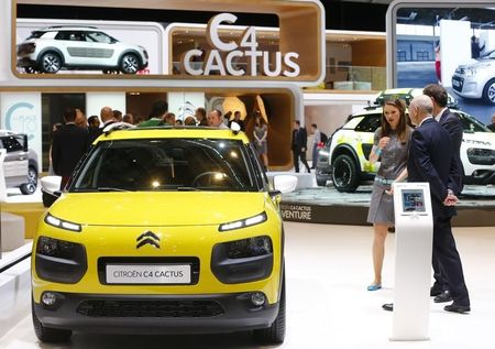 © Reuters. Visitors chat next to a Citroen C4 Cactus car during the media day ahead of the 84th Geneva Motor Show at the Palexpo Arena in Geneva