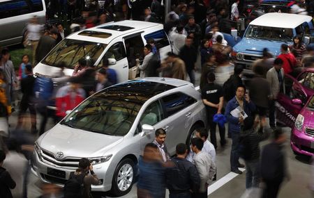 © Reuters. File photo shows people looking at Toyota cars during the Shanghai International Automobile Industry Exhibition