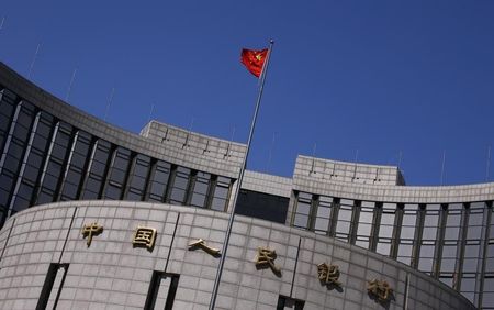 © Reuters. A Chinese national flag flutters outside the headquarters of the People's Bank of China in Beijing