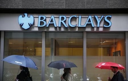 © Reuters. Pedestrians shelter under umbrellas as they walk past a Barclays branch in central London