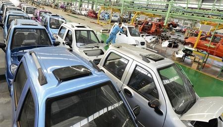 © Reuters. Employees push a newly-assembled electric car to be exported to South America along a production line at an electric vehicle factory in Zouping county