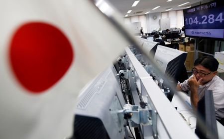 © Reuters. Un impiegato al lavoro alla Borsa di Tokyo