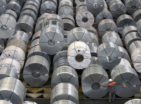 © Reuters. An employee inspects rolls of steel at the plant of German steel company Salzgitter AG in Salzgitter