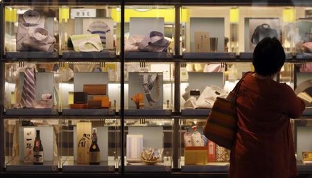 © Reuters. A woman looks at items displayed outside a luxury department store in Tokyo