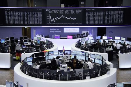 © Reuters. Traders are pictured at their desks in front of DAX board at the Frankfurt stock exchange