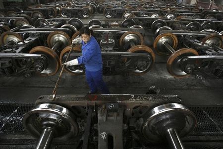 © Reuters. A labourer paints antirust oil on vehicle at a factory in Wuhan