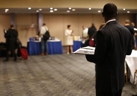 © Reuters. A job seeker stands in a room of prospective employers at a career fair in New York City