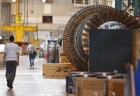 © Reuters. A worker walks past a gas turbine under construction at the gas turbines production unit of the General Electric plant in Belfort