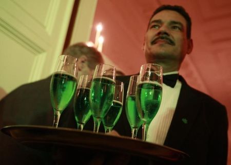 © Reuters. A waiter serves green champagne during a St Patrick's Day reception at the White House