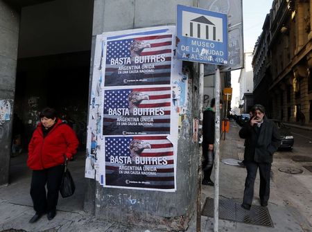 © Reuters. Pedestrians stand next to posters that read 