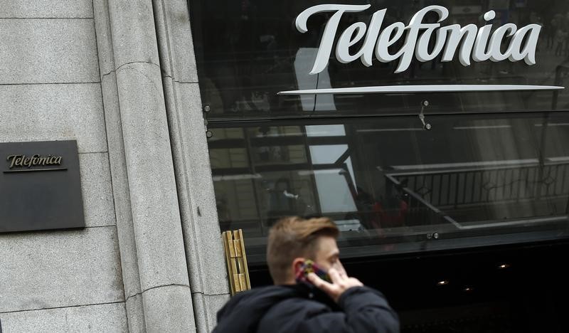 &copy; Reuters. A man talks on a mobile phone as he walks past Spanish telecom group Telefonica flagship store in central Madrid