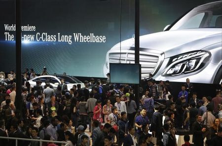 © Reuters. People look at new Mercedes Benz cars at Auto China 2014 in Beijing