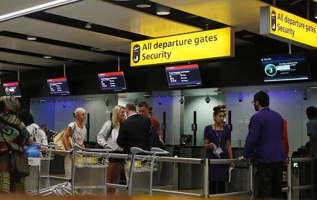 © Reuters. Pasajeros se dirigen hacia un puesto de control de seguridad en el aeropuerto de Heathrow, en Londres