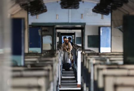 © Reuters. A passenger walks through parked train carriage at railway station in Ahmedabad