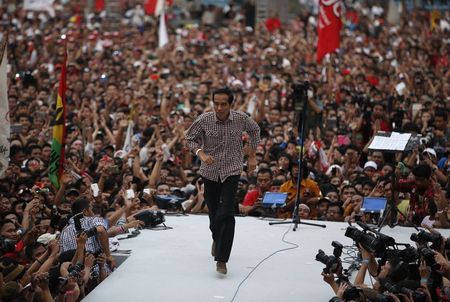 © Reuters. Indonesian presidential candidate Joko "Jokowi" Widodo runs on the stage after delivering a speech in front of his supporters at Gelora Bung Karno stadium in Jakarta