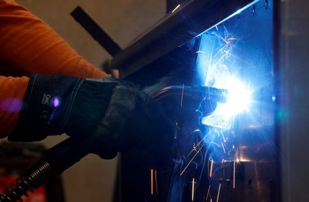 © Reuters. A worker welds in a factory in Gravellona Lomellina