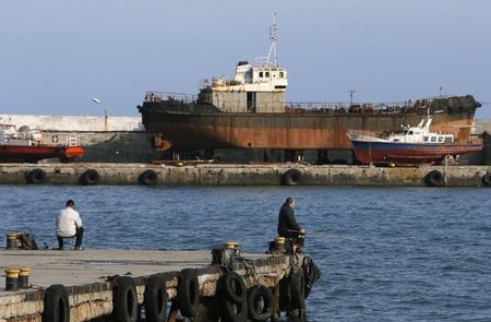 © Reuters. Люди рыбачат на причале в Ялте