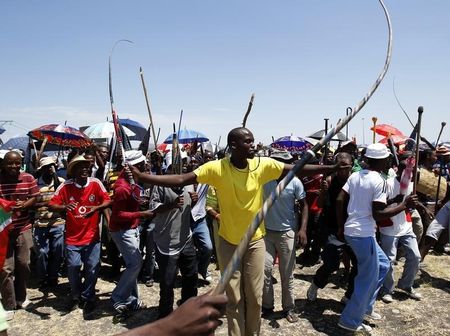 © Reuters. Miners on strike chant slogans as they wait for suspended ANC Youth League President Julius Malema to address them outside the Impala platinum mine in Rustenburg