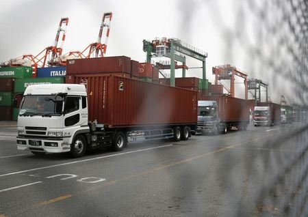 © Reuters. Trucks line up after they loaded containers at a port in Tokyo