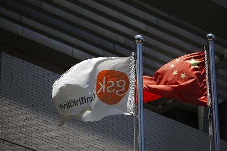 © Reuters. A flag bearing the logo of GlaxoSmithKline flutters next to a Chinese national flag outside a GlaxoSmithKline office building in Shanghai