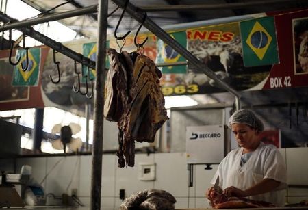 © Reuters. Uma açougueira corta peças de carne enquanto espera por clientes, em Cuiabá. 