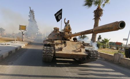 © Reuters. Militant Islamist fighters on a tank take part in a military parade along the streets of northern Raqqa province