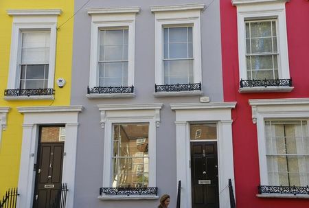 © Reuters. A woman walks along a residential street in Notting Hill in central London