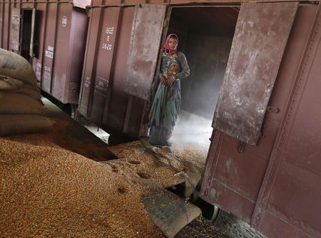 © Reuters. A worker stands as she looks on after unloading sacks filled with maize from a goods train at a railway yard in the western Indian city of Ahmedabad