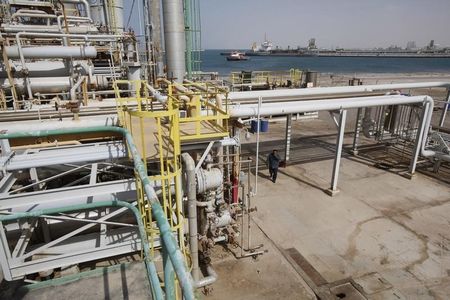 © Reuters. An anti-government rebel walks at the oil terminal of Brega