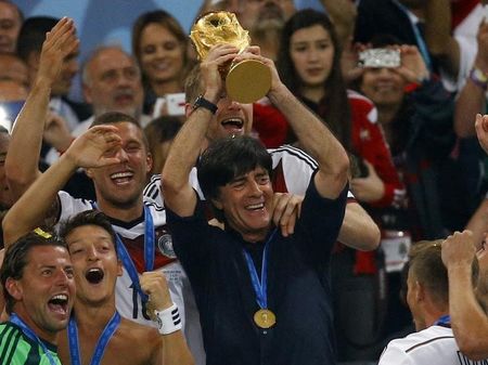 © Reuters. Técnico da Alemanha, Joachim Loew, ergue a taça da Copa do Mundo
