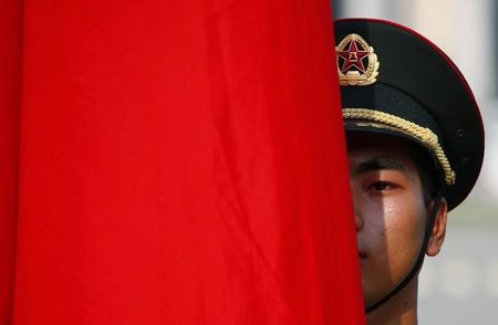 © Reuters. An honour guard member is seen behind a red flag during a welcoming ceremony for Kuwait's Prime Minister Sheikh Jaber al-Mubarak al-Sabah at the Great Hall of the People in Beijing