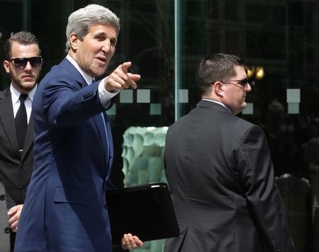 © Reuters. U.S. Secretary of State Kerry points to journalists as he walks to a meeting at a hotel in Vienna