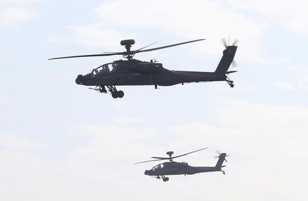 © Reuters. AH-64E Apache attack helicopters which are equipped with AN/APG-78 Longbow Fire Control Radar and purchased from the U.S. take part during a commissioning ceremony at the Tainan military base