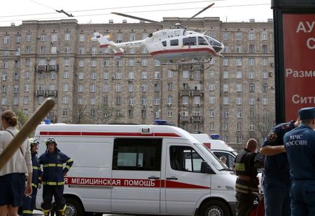 © Reuters. Вертолет МЧС и машина скорой помощи у станции московского метро