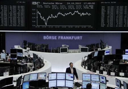 © Reuters. Traders are pictured at their desks in front of the DAX board at the Frankfurt stock exchange