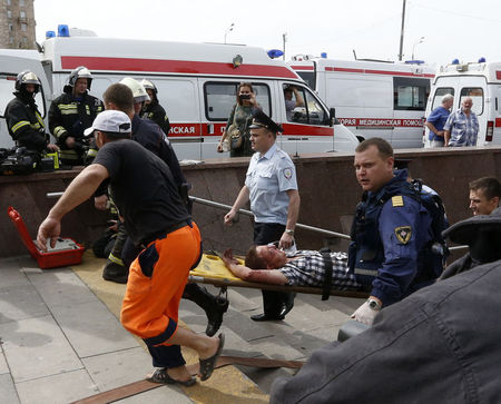 © Reuters. Membros de equipes de emergência resgatam vítimas de acidente no metrô em Moscou