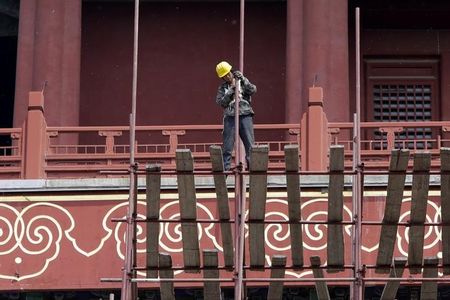 © Reuters. A labourer works at the Drum Tower in Beijing