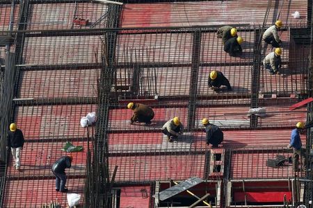 © Reuters. Shanghai, operai al lavoro in un cantiere edile