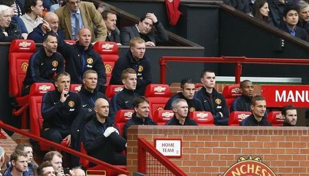 © Reuters. Manchester United players and coaching staff sit on the bench before their English Premier League soccer match against Hull City at Old Trafford in Manchester