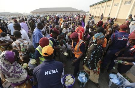 © Reuters. People, fleeing deteriorating humanitarian conditions and inter-religious violence in Central African Republic, queue at a food line for lunch rations at a transit camp at Nnamdi Azikiwe International Airport in Abuja