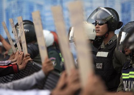 © Reuters. Police officers block a street as protesters demand the release of five opposition members of parliament, near the Phnom Penh Municipal Court