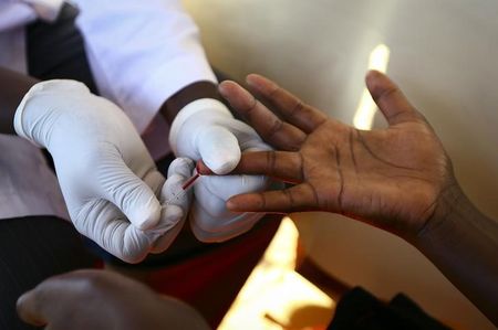 © Reuters. Médico retira amostra de sangue de um homem para exame de HIV/AIDS em um laboratório móvel, em Ndeeba, subúrbio de Kampala, capital de Uganda