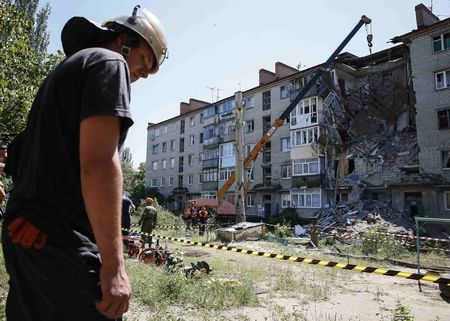 © Reuters. Rescuers work at a shattered five-storey building, which was damaged by a recent shelling, in the eastern Ukrainian town of Slaviansk