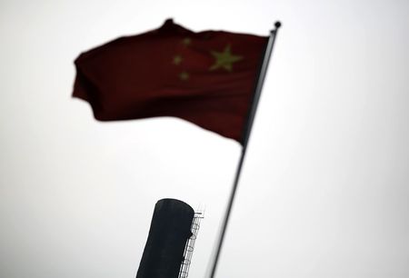 © Reuters. A Chinese national flag is seen in front of the chimney of a heat supply plant in Beijing