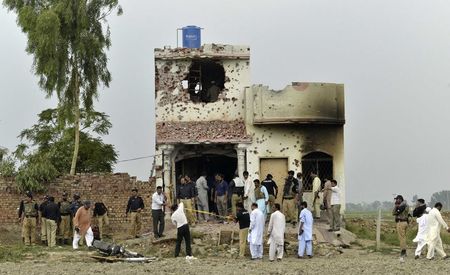 © Reuters. Security officials search a house after a gun battle with militants on the outskirts of Lahore