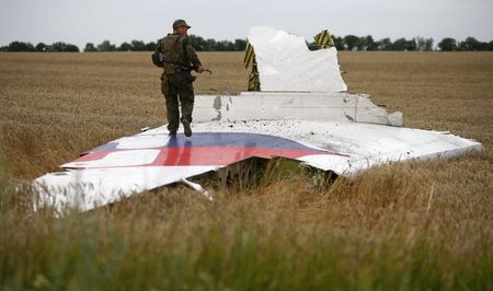 © Reuters. Separatista armado pró-Rússia sobre destroço do avião da Malaysia que caiu na Ucrânia