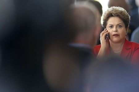 © Reuters. Brazil's President Dilma Rousseff talks on a cell phone during the meeting of China and CELAC at Itamaraty Palace in Brasilia